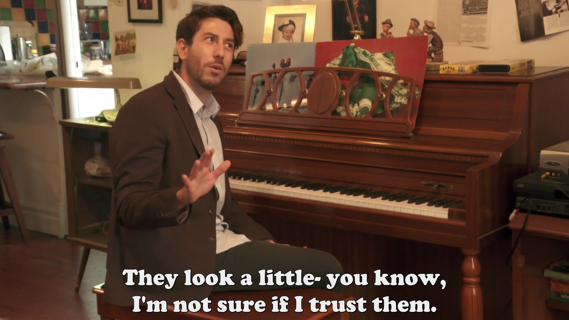 Jay sitting at the piano saying, “They look a little- you know, I'm not sure if I trust them.”.